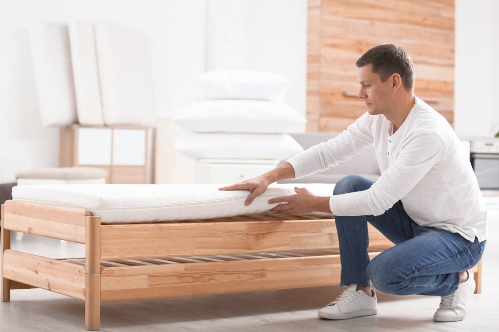 man feeling a mattress